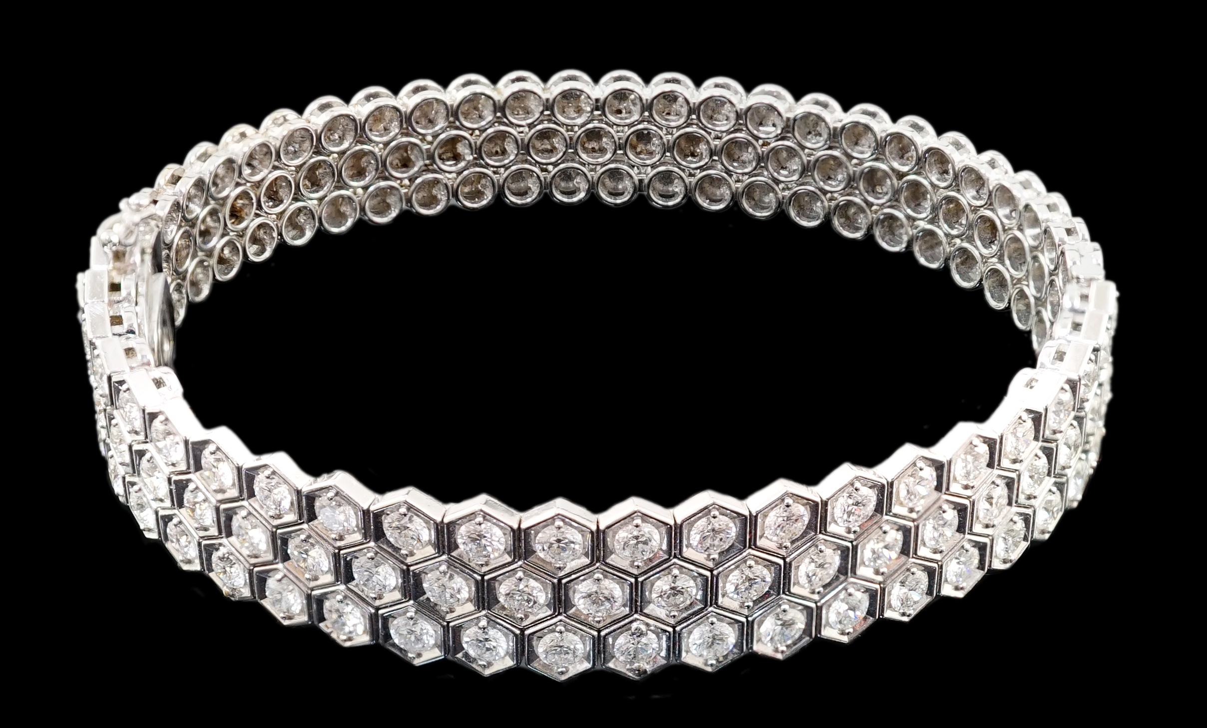 A modern 18ct white gold and diamond cluster set hinged bangle